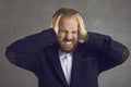 Stressed annoyed man covers his ears with his hands protecting from a loud noise Royalty Free Stock Photo