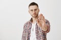 Stop drinking and go home. Portrait of serious and worried young man in glasses pulling palm towards camera in enough or