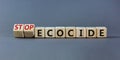 Stop ecocide symbol. Turned wooden cubes with words stop ecocide. Beautiful grey background, copy space. Business, ecological and