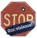 A stop gun violence sticker is seen on a traffic stop sign that has a bullet hole in the sign Royalty Free Stock Photo