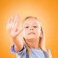 Stop, hand and portrait of girl child in studio with no, warning or vote on orange background space. Protest, palm and