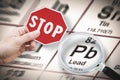 Stop heavy metals - Concept image with hand holding a stop sign against a Lead chemical element with the Mendeleev periodic table Royalty Free Stock Photo