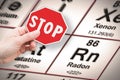 Stop heavy metals - Concept image with hand holding a stop sign against a radon chemical element with the Mendeleev periodic table