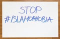 Stop Islamophobia words written on the white paper with hashtag as message and symbol from islamic muslim people