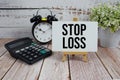 Stop Loss text with alarm clock and calculator on wooden background Royalty Free Stock Photo