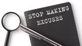 STOP MAKING EXCUSES - business concept, magnifier with white text message on black notebook