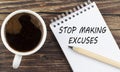 STOP MAKING EXCUSES text on notebook with coffee on wooden background Royalty Free Stock Photo