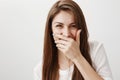 Stop making me laugh so hard. Portrait of charming positive caucasian girl covering mouth while chuckling, hearing funny