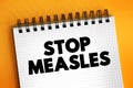 Stop Measles - get the measles, mumps, and rubella MMR vaccine, text concept on notepad Royalty Free Stock Photo