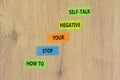 Stop negative self-talk symbol. Concept words How to stop your negative self-talk on colored paper. Beautiful wooden table wooden