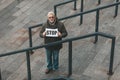 Stop offense. Elderly protester holding a placard, demonstration. Human rights activist