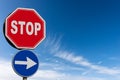 Stop and One Way Road Sign against a Clear Blue Sky and Clouds Royalty Free Stock Photo