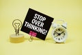 Stop Over Thinking text message on paper card with alarm clock on yellow background Royalty Free Stock Photo