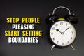 Stop People Pleasing Start Setting Boundaries text with alarm clock on black background Royalty Free Stock Photo