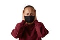 Stop please. Frowning young european woman wears face mask and burgundy sweatshirt, closes ears with hands, does not want to hear