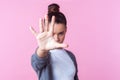 Stop! Portrait of angry teenage girl showing prohibition ban block gesture with palm, negative expression. studio shot, pink