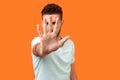 Stop! Portrait of bossy brunette man showing prohibition gesture. indoor studio shot on orange background