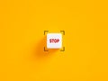 Stop push button. The word stop on white cube on yellow background Royalty Free Stock Photo