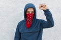 Stop racism. Photo of protester with red bandana mask raises fist, activist of community against afro citizens lawlessness, guy