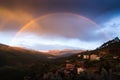 After stop the rain, the sun appeared between the clouds to created this beautiful double rainbow. The rainbow seemed connect the Royalty Free Stock Photo