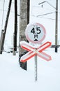 Stop. Red road sign is located on the motorway crossing the railway line in winter season Royalty Free Stock Photo