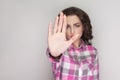 Stop it. serious unhappy girl with pink checkered shirt, curly h