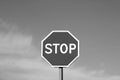 Stop sign against cloudy sky in black and white. Royalty Free Stock Photo