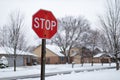 Stop Sign along a Snow Covered Neighborhood Street with Homes during Winter in Suburban Lemont Illinois Royalty Free Stock Photo