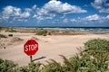 A stop sign buried in the sand