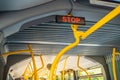 Stop sign in city bus. Empty bus interior. Bus with blue seats and yellow handrails Royalty Free Stock Photo