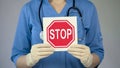 Stop sign in female physician hands, doctor warning about diseases, health care Royalty Free Stock Photo