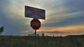 A STOP sign in front of a railway crossing. Red against the background of a bright sunset at dusk. Royalty Free Stock Photo