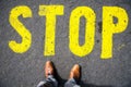 Stop sign on the ground  in front of feets Royalty Free Stock Photo