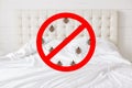 Stop sign with insects against bed background. There should be any bugs in bedroom. Hotel room being testified on cleanliness and Royalty Free Stock Photo