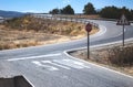 Stop sign and markings on the road at a two-way crossroad in a countryside scene Royalty Free Stock Photo