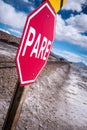 Stop sign (pare) at railway crossing in a desolate landscape