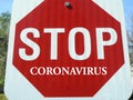 Stop Sign On Street With Coronavirus Text Warning