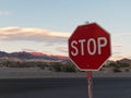 Stop Sign with Sunset Background over Desert Mountains