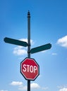 A stop sign and two empty street signs against blue sky and white clouds Royalty Free Stock Photo