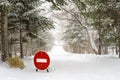 Stop Sign on winter country forest Road under snowfall