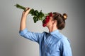 Stop and smell the roses. Studio shot of an unrecognizable man holding flowers against a grey background. Royalty Free Stock Photo