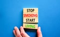 Stop smoking start living symbol. Concept words Stop smoking start living on cubes. Beautiful blue background. Doctor hand.