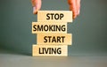 Stop smoking start living symbol. Concept words Stop smoking start living on cubes. Beautiful grey background. Doctor hand.