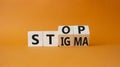 Stop and Stigma symbol. Businessman hand points at wooden cubes with words Stop and Stigma. Beautiful orange background. Business Royalty Free Stock Photo