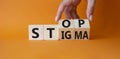 Stop and Stigma symbol. Concept words Stop and Stigma on wooden cubes. Beautiful orange background. Businessman hand. Business and Royalty Free Stock Photo