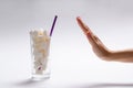 Stop sugar! A full glass of sugar and a woman`s hand with a refusal gesture.