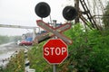 Stop traffic sign and semaphore next to the old railway crossing. Against the backdrop of a pipeline and a car park