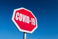 A stop traffic sign to block spreading COVID-19 disease with blue sky