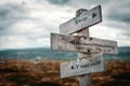 Stop underestimating yourself text on wooden rustic signpost outdoors in nature/mountain scenery.