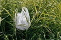 Stop using plastic products. Close up shot of a plastic bag on the green grass in park Royalty Free Stock Photo